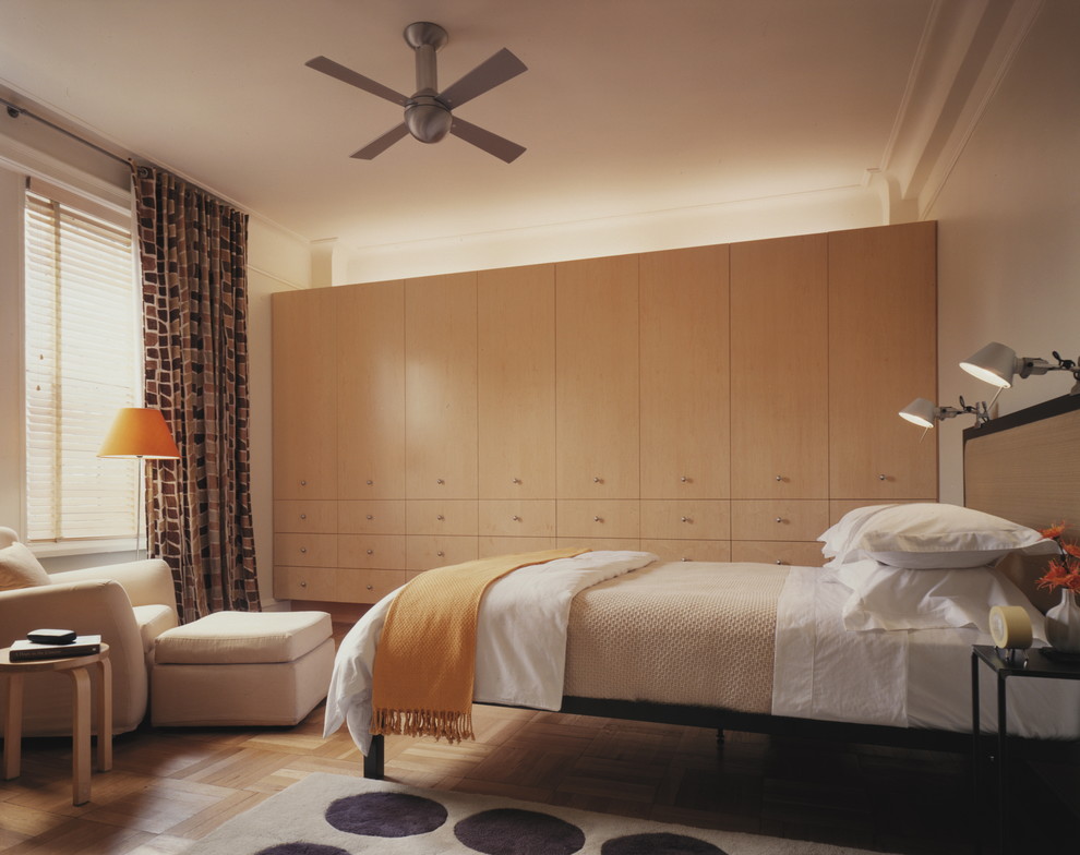 Foto på ett funkis sovrum, med beige väggar och mellanmörkt trägolv