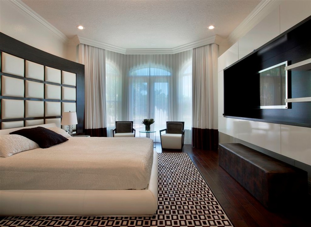 Идея дизайна: спальня в современном стиле с серыми стенами, темным паркетным полом, телевизором и кроватью в нише