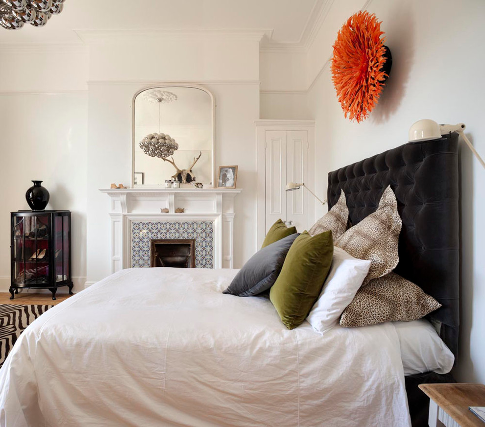 Cette photo montre une chambre tendance avec un mur blanc, une cheminée standard et un manteau de cheminée en carrelage.