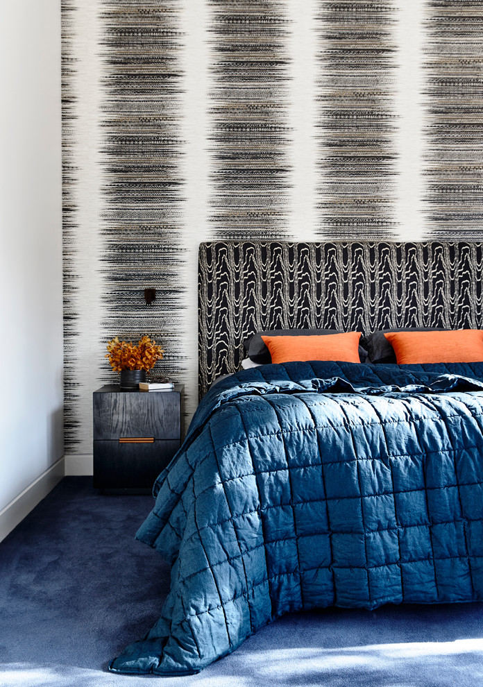 Idée de décoration pour une très grande chambre avec moquette design avec un mur multicolore et un sol bleu.
