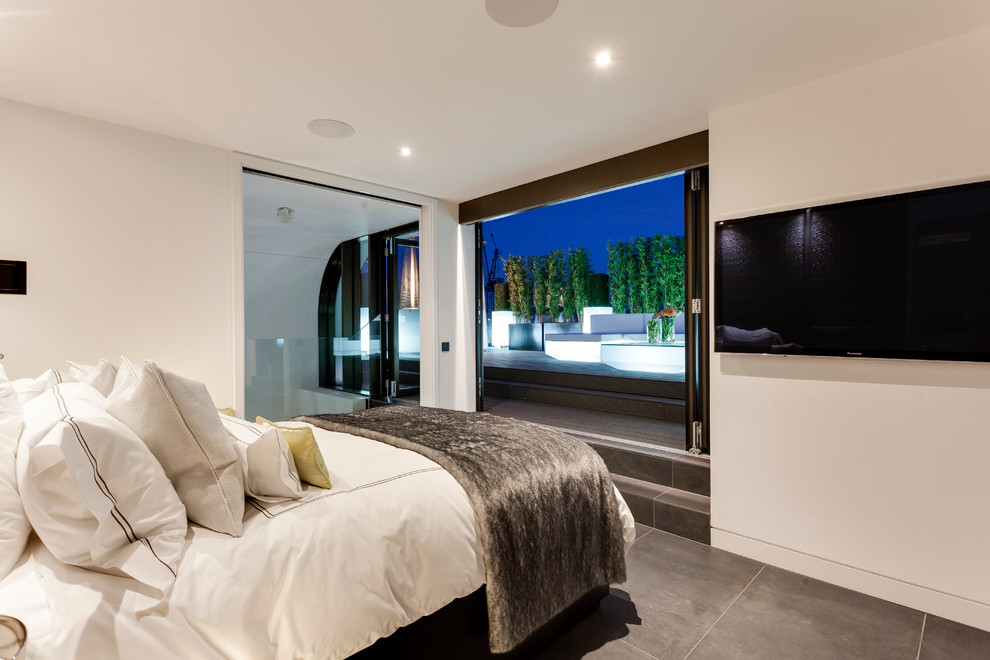 Modernes Hauptschlafzimmer ohne Kamin mit weißer Wandfarbe und Betonboden in London