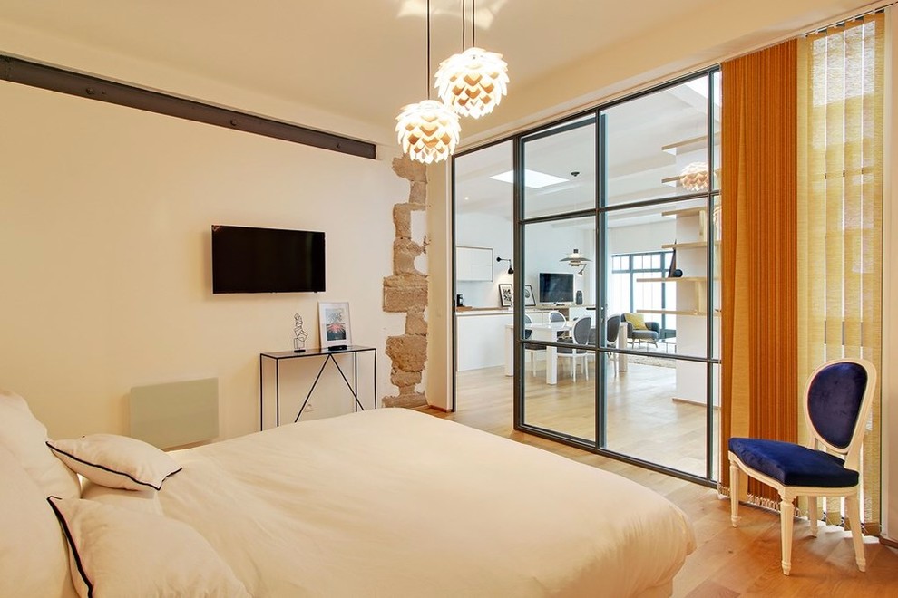 Ejemplo de dormitorio principal contemporáneo de tamaño medio sin chimenea con paredes blancas y suelo de madera en tonos medios