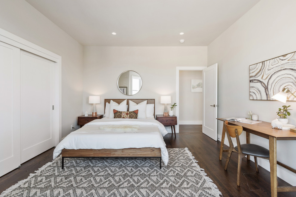 Modelo de dormitorio principal contemporáneo de tamaño medio con paredes grises, suelo de madera en tonos medios y suelo marrón
