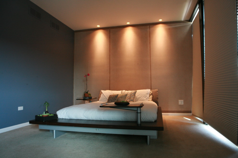 Immagine di una camera matrimoniale minimal di medie dimensioni con pareti blu, moquette e nessun camino