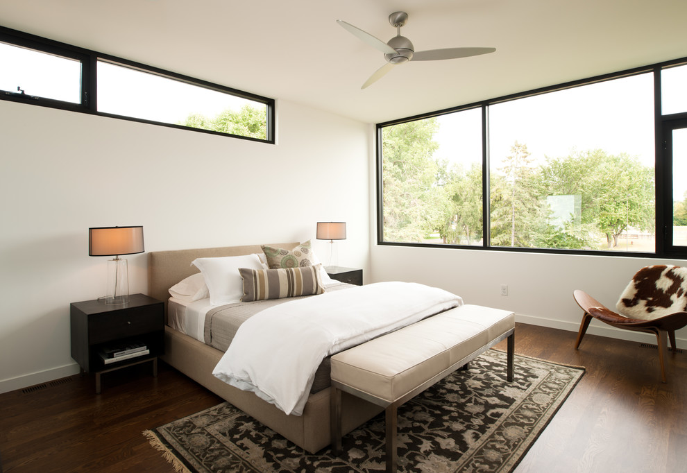 Imagen de dormitorio contemporáneo con paredes blancas y suelo de madera oscura