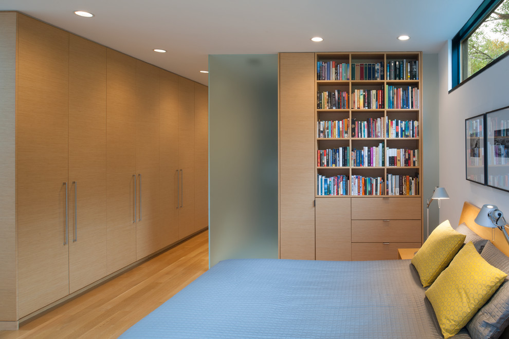 Idee per una camera da letto design con pareti bianche, parquet chiaro e pavimento beige