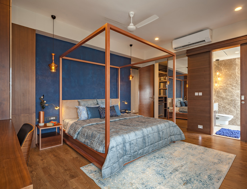 Immagine di una camera matrimoniale design con pavimento in legno massello medio, pavimento marrone e pareti blu