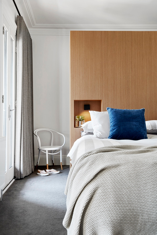Idee per una camera da letto design con moquette e pareti bianche