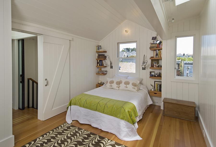 Small trendy guest medium tone wood floor and brown floor bedroom photo in San Francisco with white walls and no fireplace