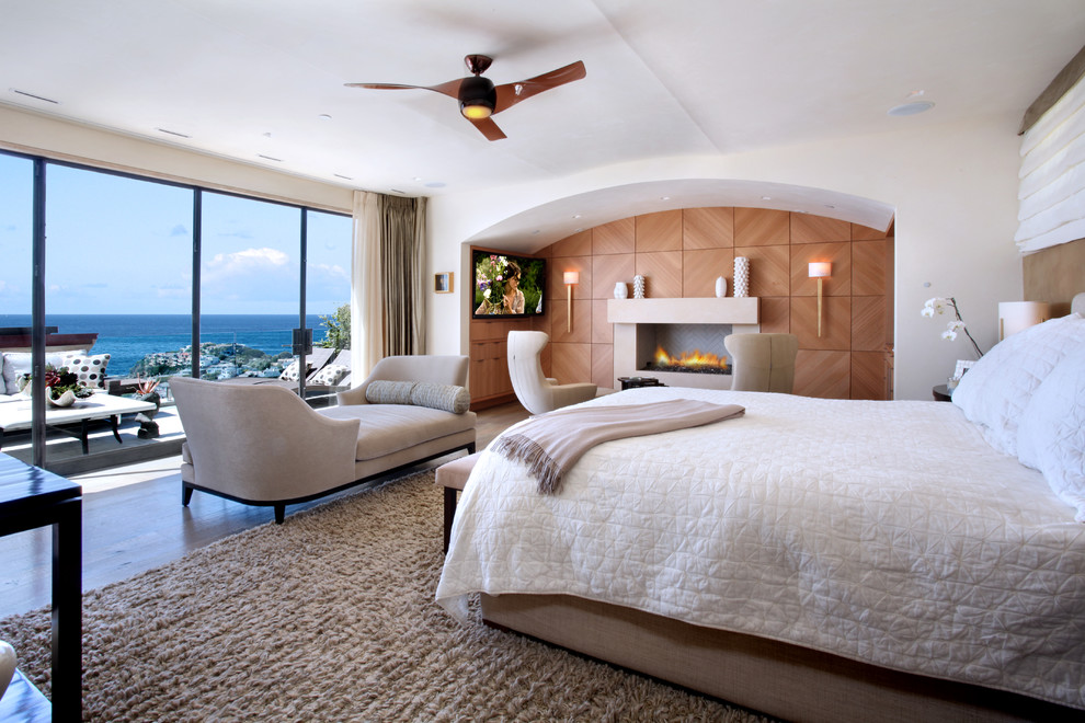 Modernes Hauptschlafzimmer mit weißer Wandfarbe und Kamin in Orange County