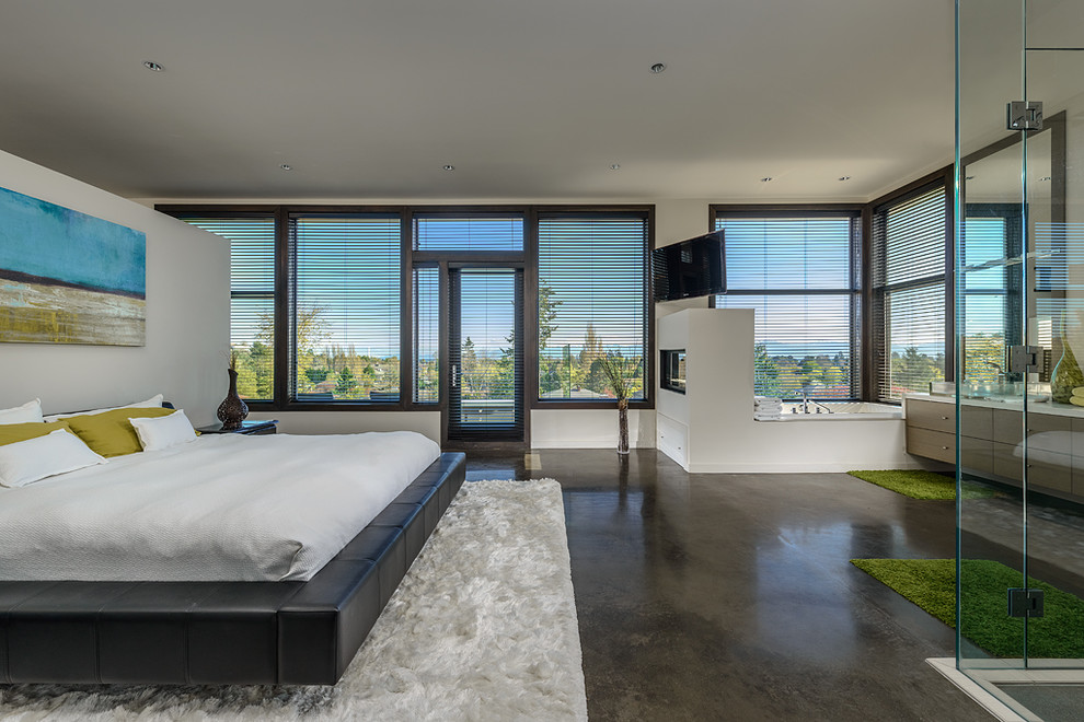 Стильный дизайн: спальня в современном стиле с бетонным полом и телевизором - последний тренд
