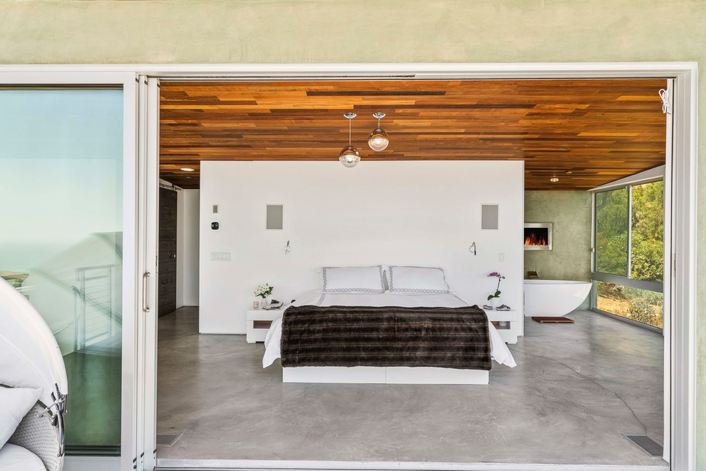 Idéer för ett modernt sovrum, med vita väggar, betonggolv, en standard öppen spis och grått golv