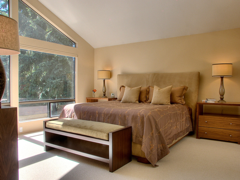 Immagine di una camera da letto design con pareti beige e moquette