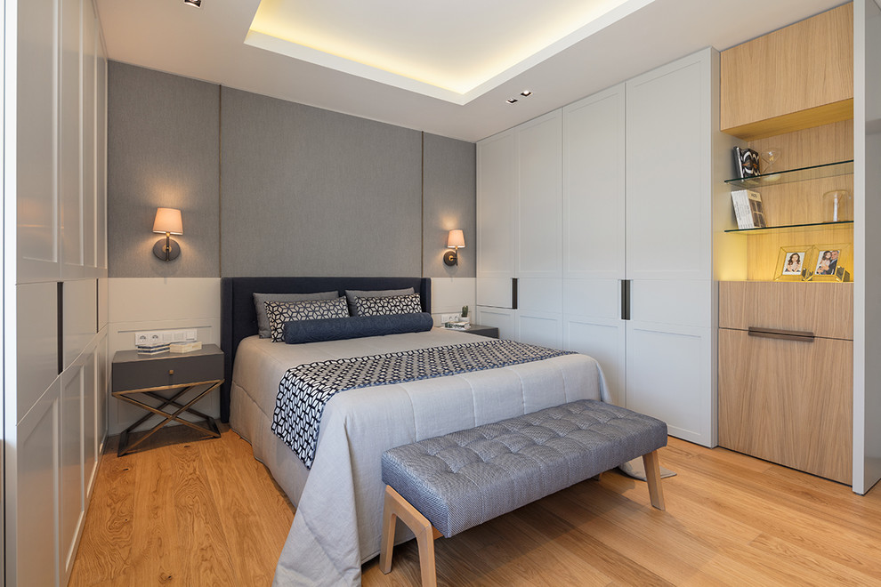 Foto de dormitorio principal actual de tamaño medio sin chimenea con paredes grises, suelo de madera en tonos medios y suelo marrón