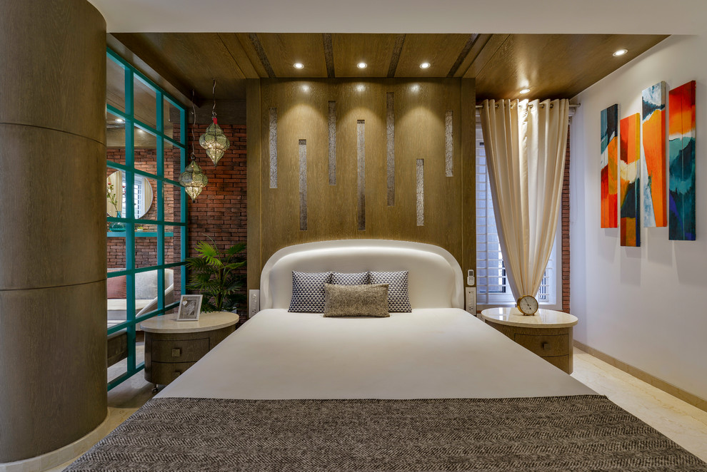 This is an example of a medium sized contemporary master bedroom in Mumbai with white walls, beige floors and a feature wall.