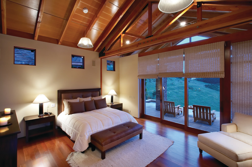 Cette image montre une chambre design avec un mur beige et un sol en bois brun.