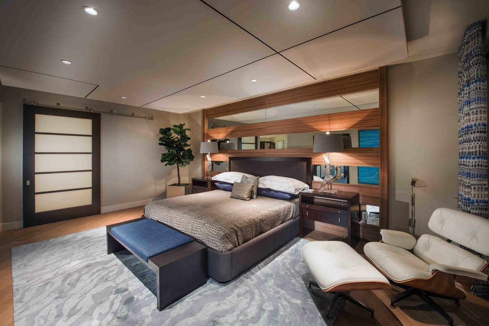 Modernes Hauptschlafzimmer mit beiger Wandfarbe und braunem Holzboden in Miami