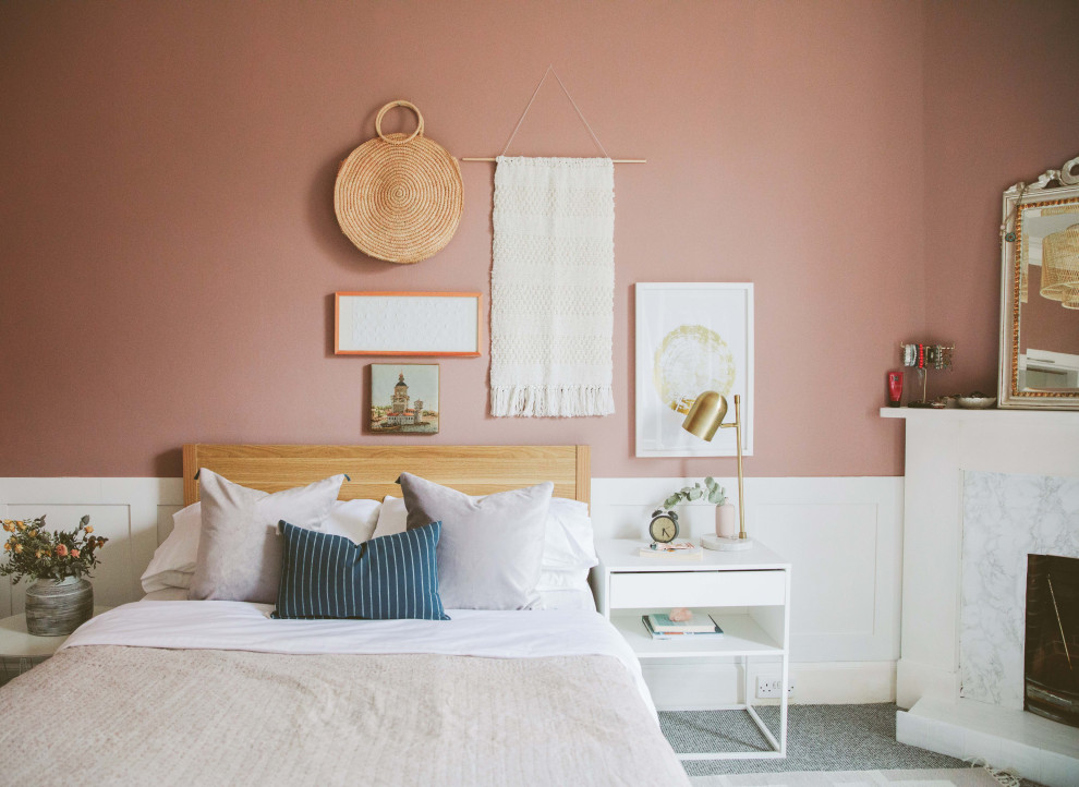 На фото: хозяйская спальня среднего размера в современном стиле с оранжевыми стенами, ковровым покрытием, стандартным камином, фасадом камина из плитки и серым полом