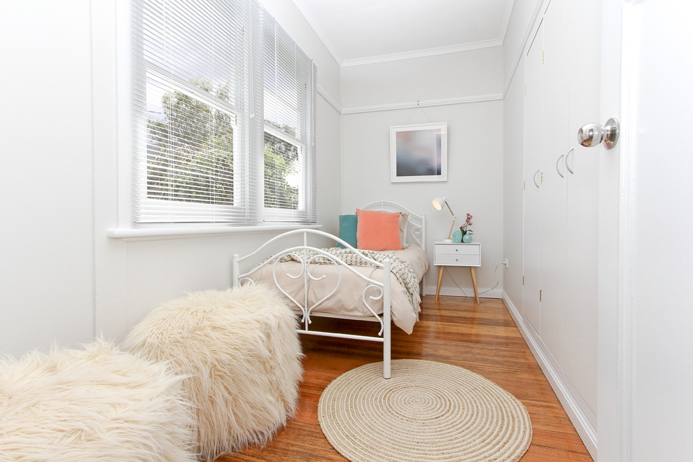 Small trendy guest medium tone wood floor bedroom photo in Hobart with gray walls