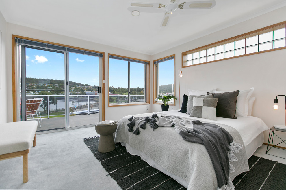 This is an example of a contemporary bedroom in Hobart with white walls, carpet and grey floors.
