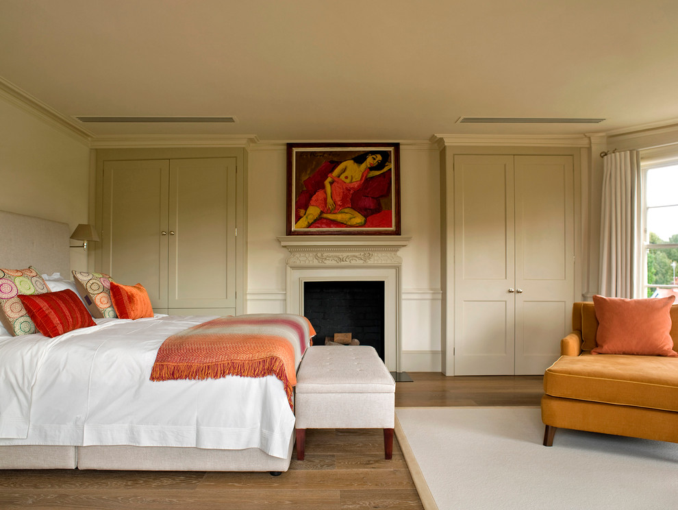 Example of a trendy medium tone wood floor bedroom design in London with beige walls