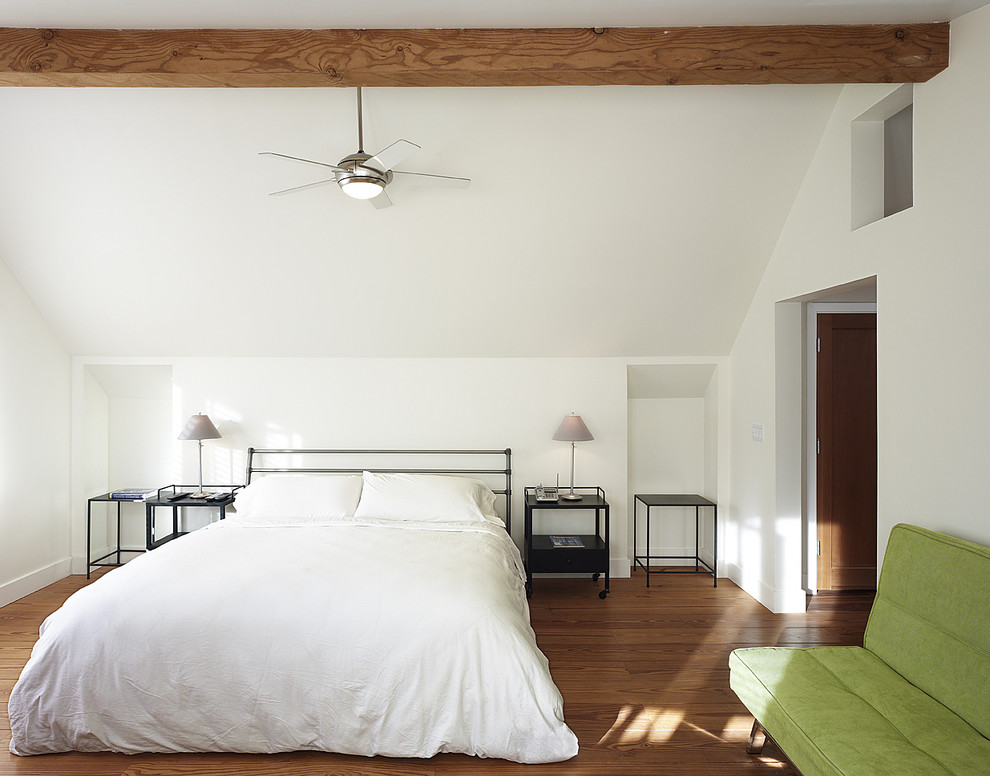 Cette image montre une chambre design avec un mur blanc et un sol en bois brun.