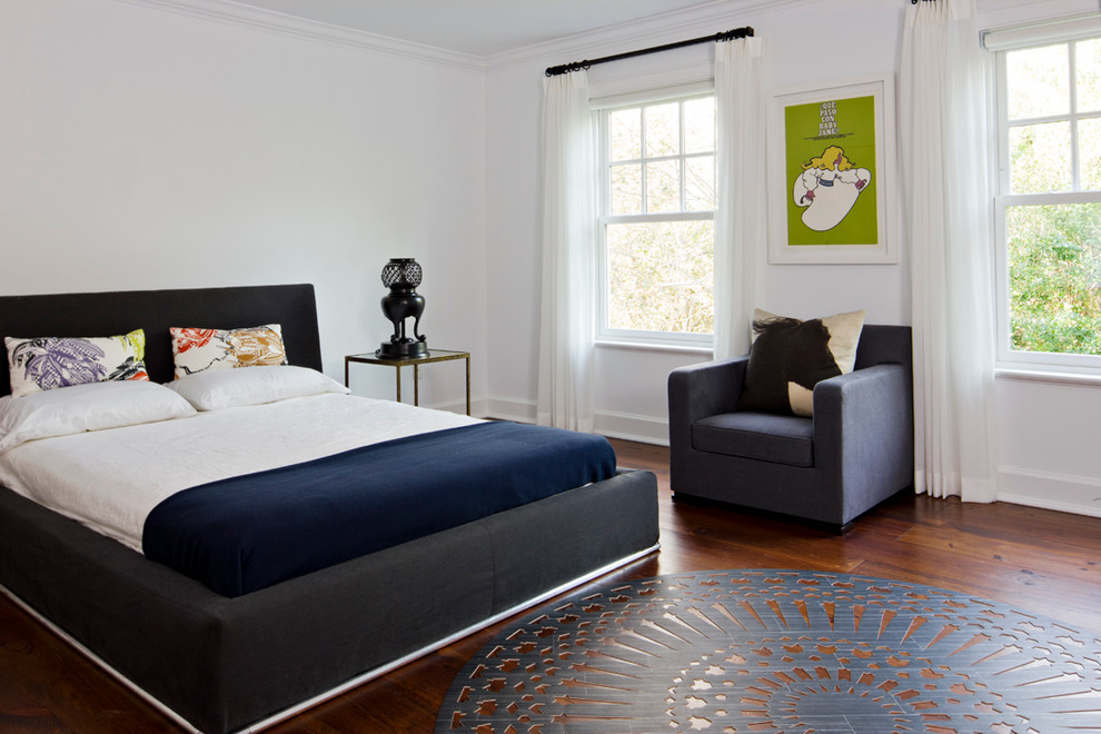 This is an example of a contemporary bedroom in New York with white walls.