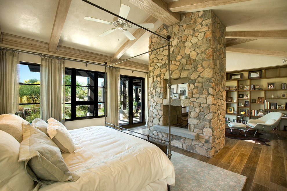 На фото: спальня в современном стиле с стандартным камином с