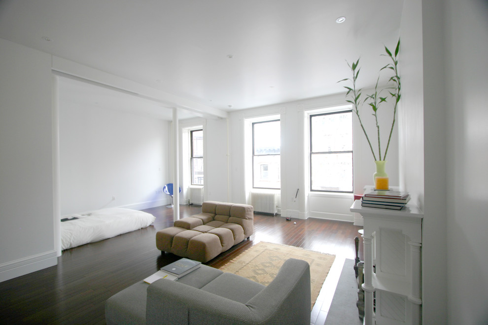 This is an example of a contemporary master loft bedroom in New York with white walls.