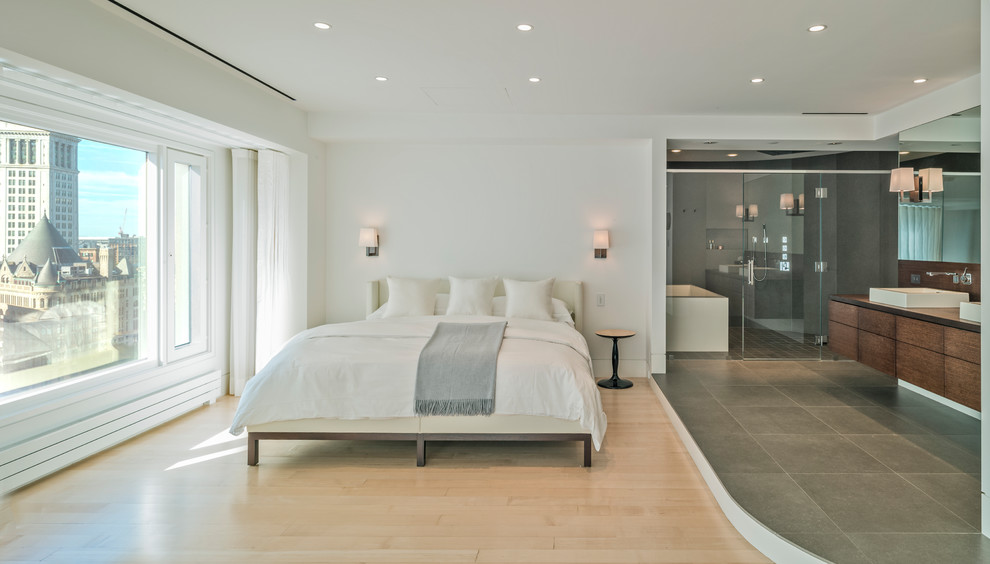Esempio di una camera matrimoniale minimal con pareti bianche, parquet chiaro e pavimento beige