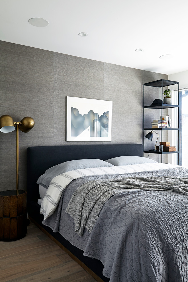 Immagine di una camera da letto minimal con pareti grigie e parquet chiaro