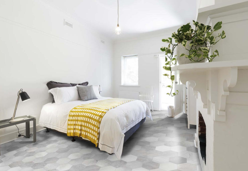 На фото: спальня среднего размера в современном стиле с белыми стенами, полом из керамогранита, стандартным камином и серым полом