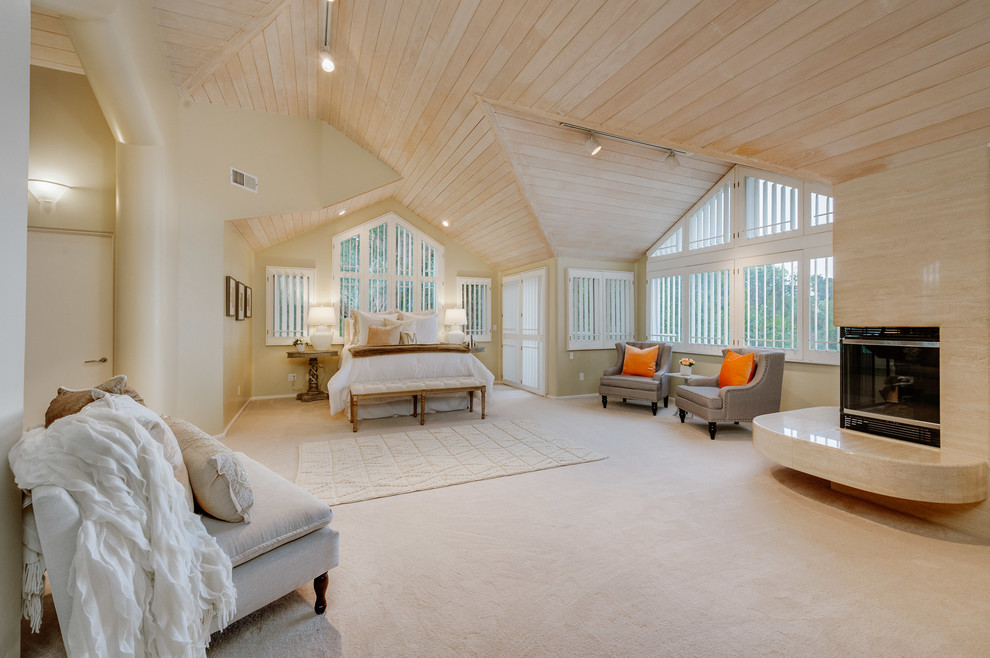 Ejemplo de dormitorio principal tradicional renovado extra grande con paredes beige, moqueta, chimenea de esquina y marco de chimenea de baldosas y/o azulejos
