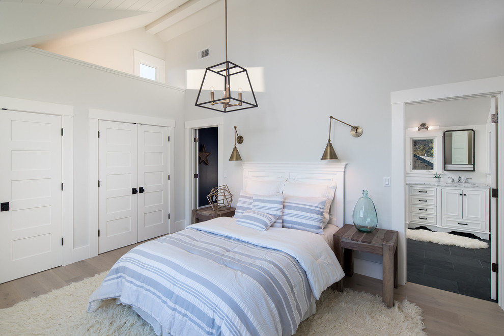 This is an example of a contemporary master bedroom in San Francisco with white walls and light hardwood flooring.