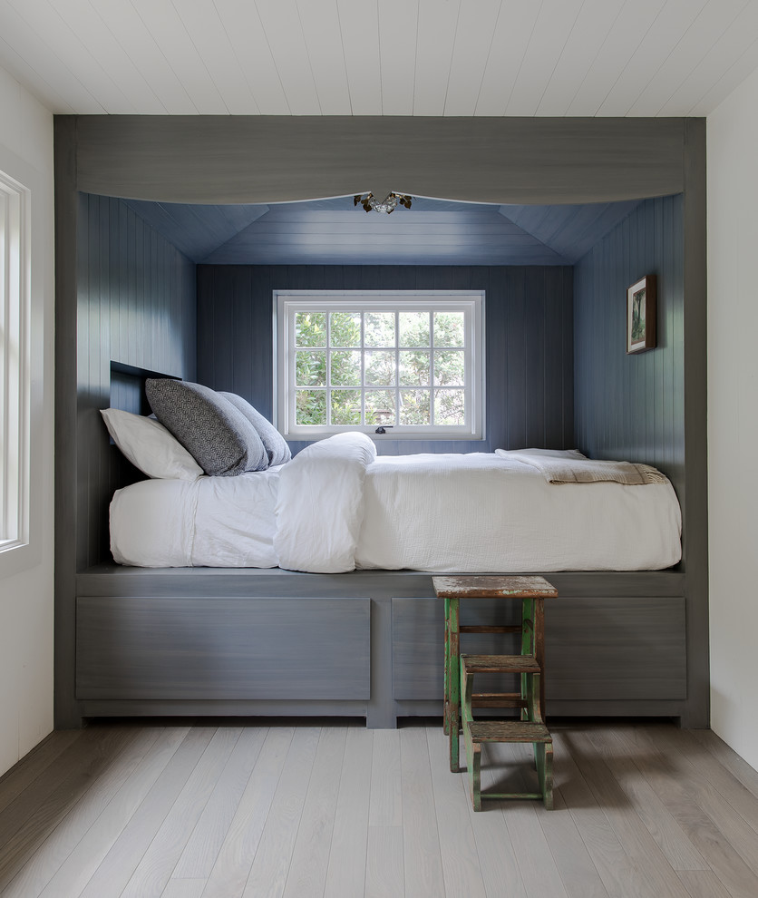 На фото: гостевая спальня среднего размера, (комната для гостей) в морском стиле с белыми стенами, паркетным полом среднего тона, коричневым полом и кроватью в нише