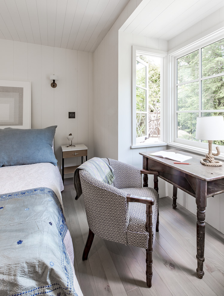 Imagen de dormitorio principal marinero de tamaño medio con paredes blancas, suelo de madera clara y suelo beige