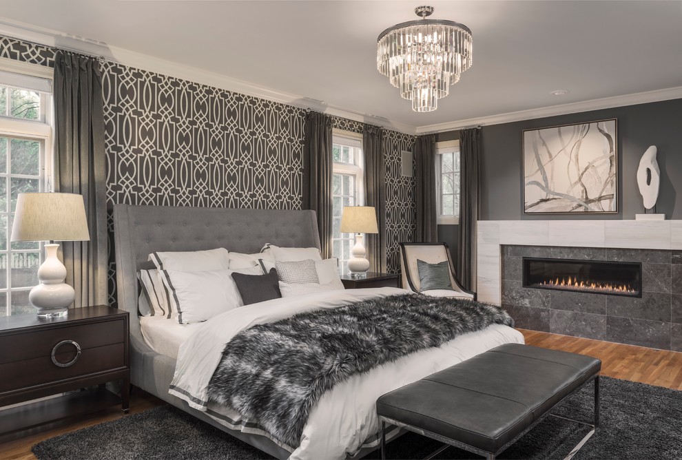 Klassisches Hauptschlafzimmer mit grauer Wandfarbe, braunem Holzboden und Gaskamin in St. Louis