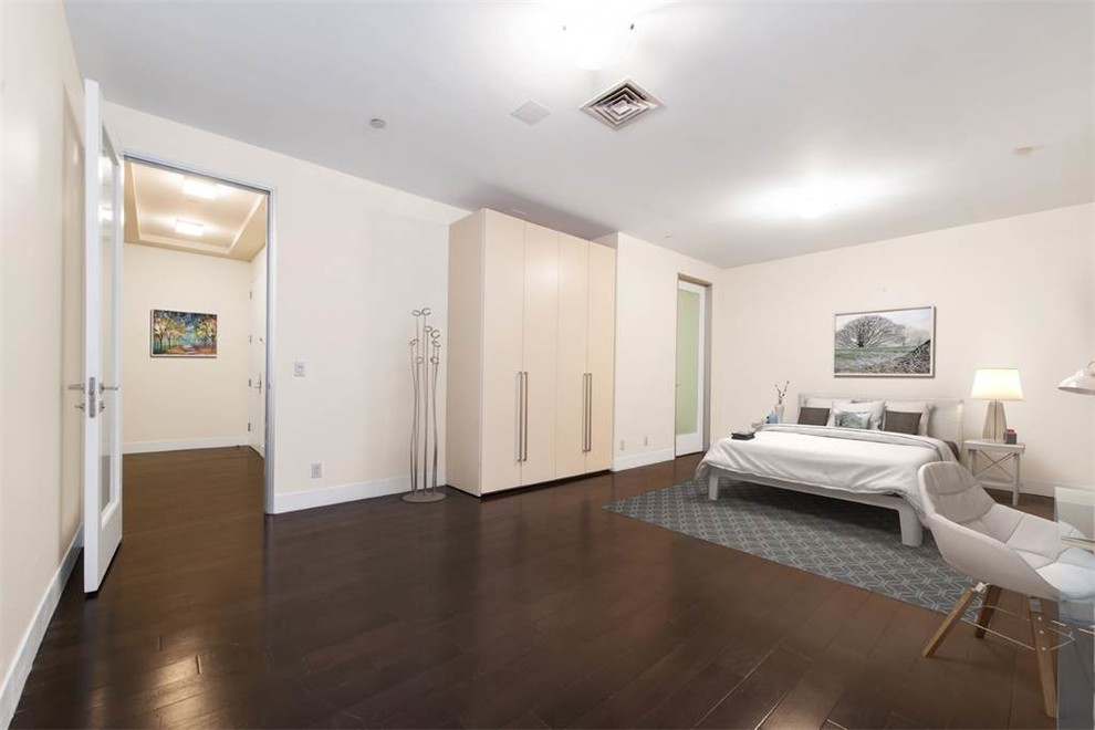 Imagen de dormitorio principal moderno grande con paredes beige, suelo de madera oscura y suelo marrón
