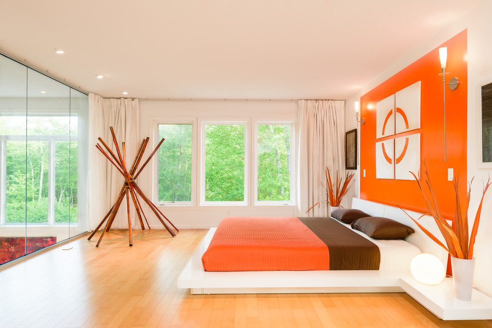 На фото: спальня в современном стиле с белыми стенами, паркетным полом среднего тона и оранжевым полом с