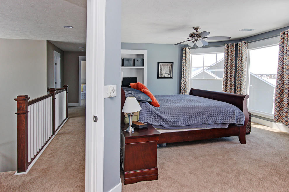 Immagine di una grande camera da letto tradizionale con pareti blu, moquette, nessun camino e pavimento marrone