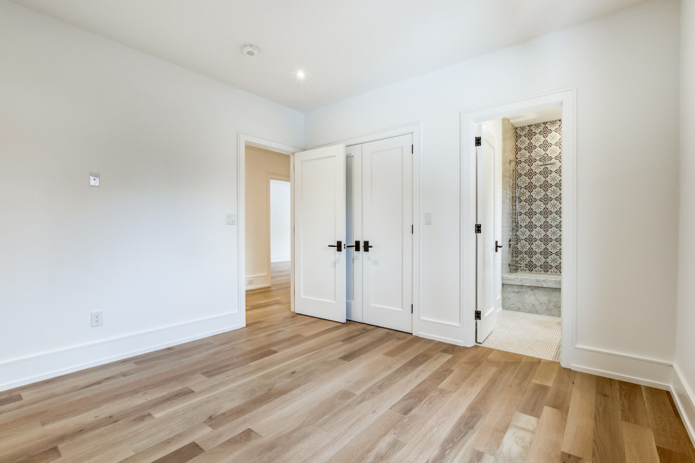 Inspiration pour une chambre d'amis design de taille moyenne avec un mur blanc, un sol en bois brun et un sol beige.