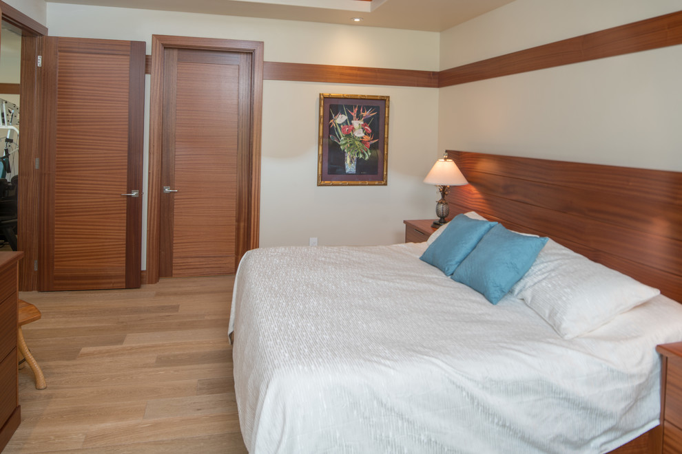 Modelo de dormitorio principal actual de tamaño medio sin chimenea con paredes blancas y suelo de madera clara
