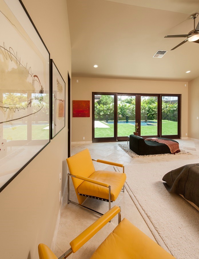 Imagen de dormitorio principal actual de tamaño medio con paredes beige y suelo de travertino