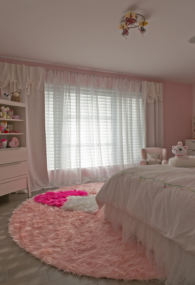 Modelo de dormitorio contemporáneo grande con paredes rosas y suelo de madera clara