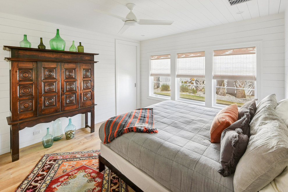 Example of a trendy light wood floor bedroom design in Jacksonville with white walls