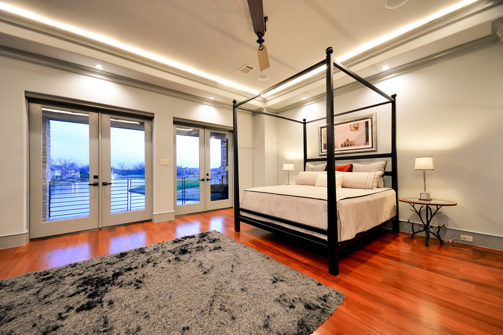 Ejemplo de dormitorio principal actual grande con paredes grises, suelo de madera en tonos medios y suelo marrón