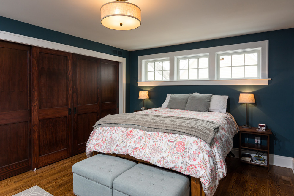 Mittelgroßes Modernes Hauptschlafzimmer ohne Kamin mit blauer Wandfarbe und braunem Holzboden in Detroit