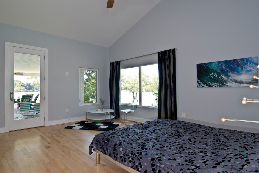 Imagen de habitación de invitados contemporánea de tamaño medio sin chimenea con paredes grises y suelo de madera clara