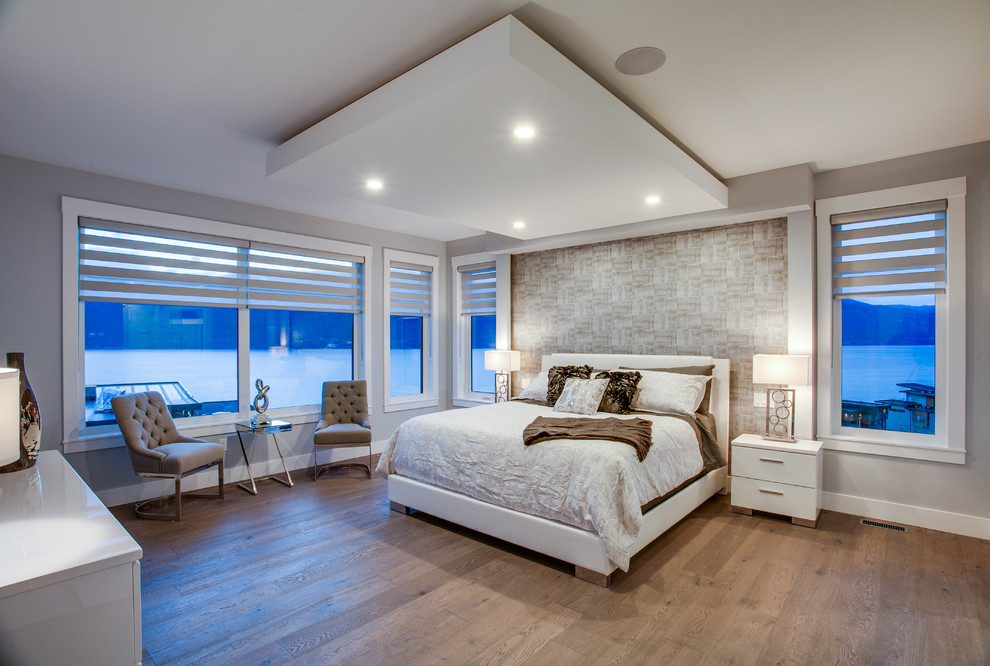 Large contemporary master bedroom in Vancouver with beige walls and dark hardwood flooring.