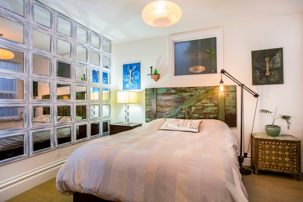 Idee per una camera da letto eclettica con pareti bianche e pavimento in legno massello medio